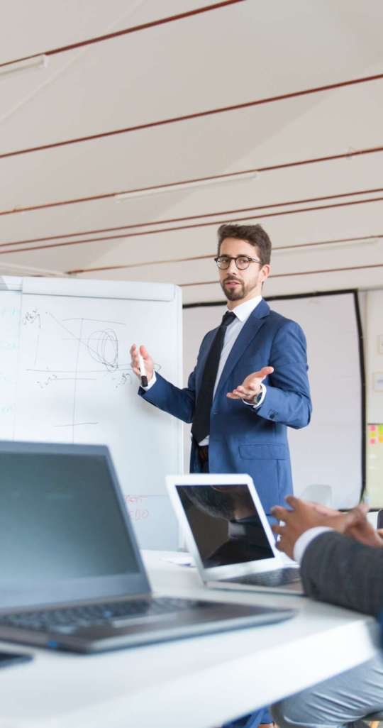 Low angle shot of speaker talking and looking at colleagues. Group of workers discussing ideas during presentation of new project at briefing. Business meeting concept